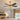 Gold ceiling fan with dark blades and crystal cage light installed in a warm transitional bedroom