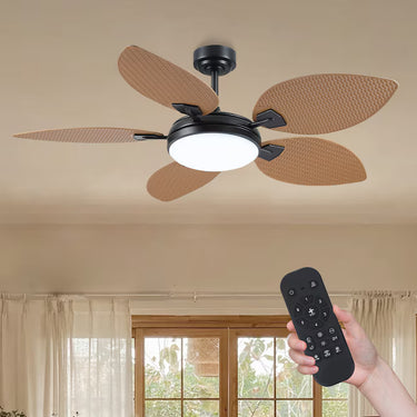 Person holding a remote control to operate the modern tropical ceiling fan installed on a white ceiling.
